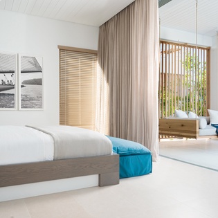 Wake up in your serene bedroom where soft ocean breezes flow through, complete with private balcony seating overlooking tropical gardens.