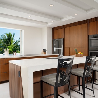 Your modern kitchen overlooks tropical paradise, where marble countertops and warm wood create the perfect space for morning coffee or evening cocktails.