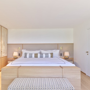 Unwind in your serene bedroom featuring warm wood tones, crisp linens, and modern elegance for the perfect night's rest.