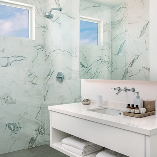 Step into your spa-like retreat with elegant marble walls and a luxurious rainfall shower that transforms your daily routine into pure bliss.