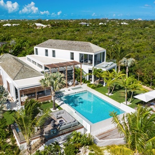 Stunning modern villa surrounded by lush tropical vegetation with pristine pool and spacious outdoor entertaining areas.