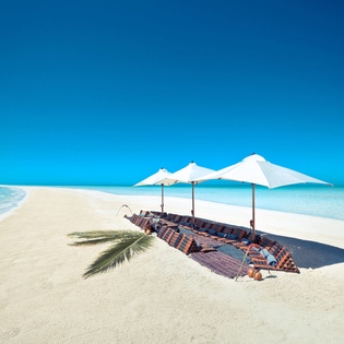 Private beachfront paradise with pristine white sand and crystal-clear turquoise waters stretching to the horizon.