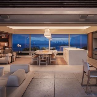Unwind in this stunning open-plan space where floor-to-ceiling windows frame breathtaking twilight views, creating the perfect backdrop for relaxation.