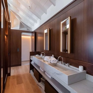 Warm wood tones and soft lighting create your private spa-like sanctuary, where every detail invites you to relax and refresh in style.