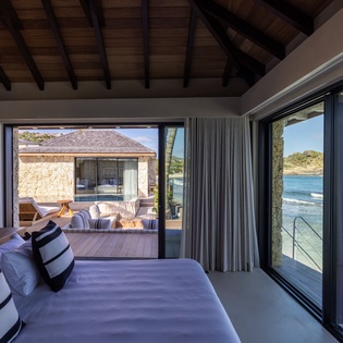 Wake up to breathtaking ocean views from your bed, with floor-to-ceiling windows opening to your private terrace and pristine waters.