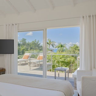 Wake up to tropical views from your bright bedroom sanctuary with private balcony access and modern comforts.