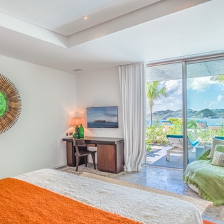 Drift off in your tropical bedroom sanctuary with stunning ocean views through floor-to-ceiling windows.
