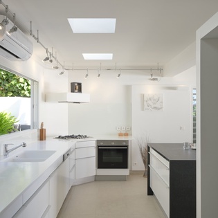 Your sleek kitchen features modern appliances and skylights that flood the space with natural light while you cook.