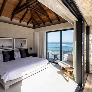 Wake up to endless ocean views from your bed, where floor-to-ceiling windows blur the line between your serene bedroom and paradise.