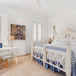 Drift into sweet dreams in your serene coastal bedroom, where nautical touches meet tropical breezes and stunning ocean views greet you each morning from soft, inviting linens.