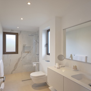 Your private bathroom features marble finishes, a rainfall shower, and modern amenities for ultimate comfort.