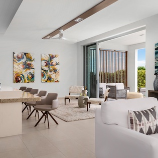Unwind in this bright, modern living space where vibrant artwork meets sleek design and ocean breezes flow through sliding doors.