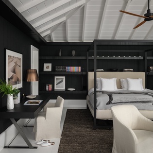 Unwind in your sophisticated suite with built-in shelving, modern four-poster bed, and elegant seating area under vaulted ceilings.