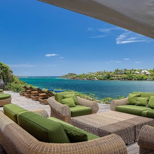Spacious waterfront terrace showcasing sweeping bay views from the property, with expansive outdoor seating arranged to enjoy the coastal setting.