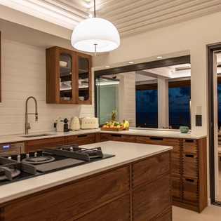 Your beautifully appointed kitchen features premium appliances and warm wood cabinetry, perfect for preparing meals while enjoying evening views.