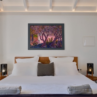 Slip into crisp linens beneath the artistic ceiling beams, where colorful artwork brightens your peaceful retreat.