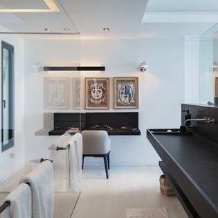 Step into your sophisticated master bathroom where sleek black vanities and contemporary art create a spa-like sanctuary for your daily rituals.