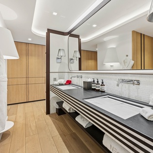 Luxurious bathroom with dual sinks, premium amenities, and warm wood accents creating your perfect spa-like retreat.