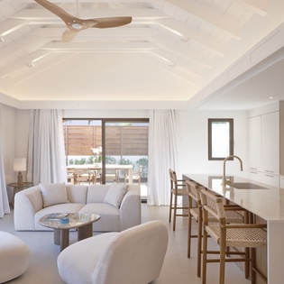 Sink into plush seating while your morning coffee brews in this airy, sunlit space with soaring ceilings and seamless indoor-outdoor flow.