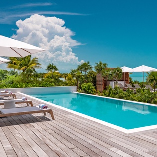 Dive into crystal-clear waters while soaking up tropical sunshine on your private deck, with turquoise ocean views stretching to the horizon.