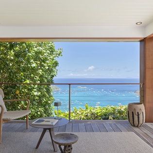 Unwind on your private terrace overlooking a stunning turquoise bay dotted with boats, framed by tropical greenery and open skies. The perfect retreat.