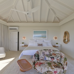 Retreat to your serene suite where vaulted ceilings and coastal-chic décor invite pure relaxation. Soft linens await you on a plush king bed, while gentle light and garden views create a tranquil escape.