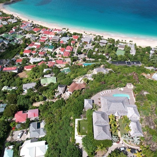 Stunning beachfront location with pristine turquoise waters and white sand beach just steps away from charming coastal properties.