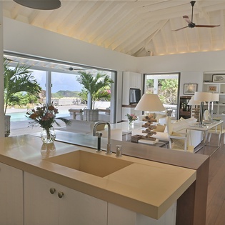 Your bright, open kitchen seamlessly flows into the living space, offering stunning pool and tropical views while you cook.
