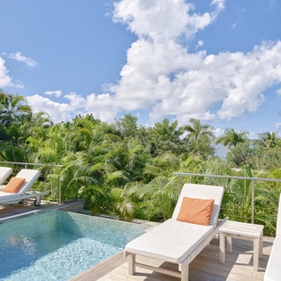 Your private pool terrace offers tranquil lounging with tropical views and orange-accented chairs for ultimate relaxation.