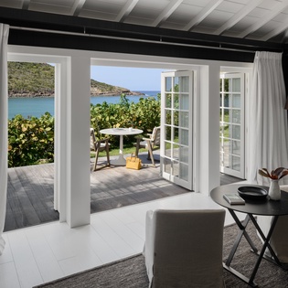 Step into your elegant living space where floor-to-ceiling windows frame stunning sea views, creating the perfect backdrop for relaxation.