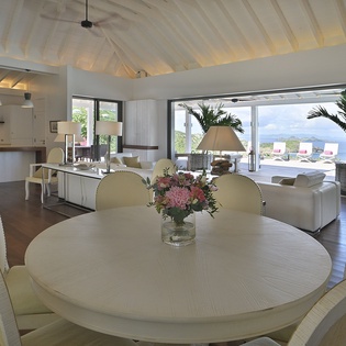 Relax in your elegant open-plan living space with stunning sea views through floor-to-ceiling windows and modern comfort.