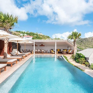 A stunning infinity pool framed by tropical palms and rolling hillsides, offering the perfect place to unwind and soak in the surrounding beauty during your island escape.