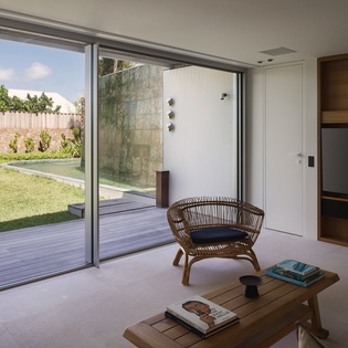 Your stylish living space opens seamlessly to private gardens through floor-to-ceiling windows, creating an airy retreat.