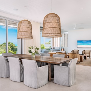 Gather around this stunning dining table where ocean views frame every meal, creating unforgettable moments in your tropical paradise.