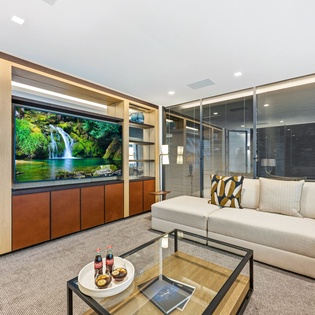 Unwind in your elegant living space featuring a large TV and comfortable seating for perfect movie nights.