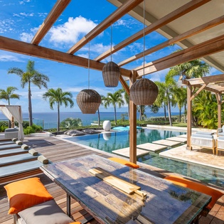 Relax on your private deck where ocean views meet tropical luxury—loungers await as you soak in paradise.