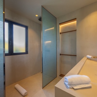 Step into your sleek bathroom sanctuary with a spacious walk-in shower and plush towels awaiting your arrival.