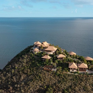 Tropical resort perched on a dramatic clifftop peninsula surrounded by endless ocean views and lush vegetation.