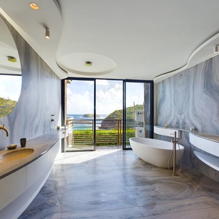 Step into your luxurious marble sanctuary where golden fixtures gleam and panoramic ocean views create a spa-like escape for your morning rituals.