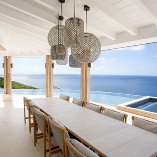 Dine with breathtaking ocean views at your elegant table, where stunning pendant lights illuminate memorable meals overlooking the infinity pool and endless sea.