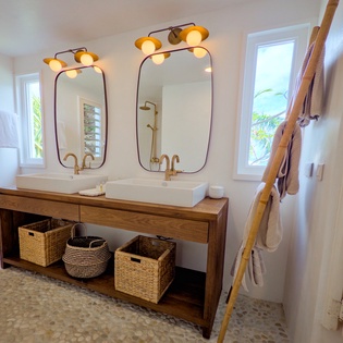 Step into your spa-like bathroom, where warm lighting, dual vessel sinks, and natural wood accents create a serene space for your morning routine or evening wind-down.