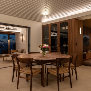 Gather around your elegant dining table as evening lights twinkle beyond floor-to-ceiling windows, creating the perfect atmosphere for memorable meals.
