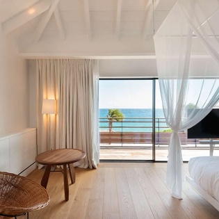 Wake up to breathtaking sea views from your airy retreat. Soft linens, natural wood tones, and direct balcony access invite you to unwind in coastal elegance.