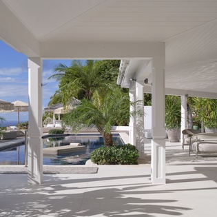 Tropical paradise awaits under your private covered terrace, where pool views and swaying palms create the perfect backdrop for relaxation.