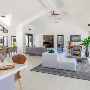 Settle into your spacious, sunlit living area where soaring vaulted ceilings and sleek modern design create an airy, sophisticated retreat for your island escape.