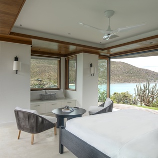 Wake up to panoramic water views from your luxurious bedroom, where floor-to-ceiling windows frame the serene landscape beyond.