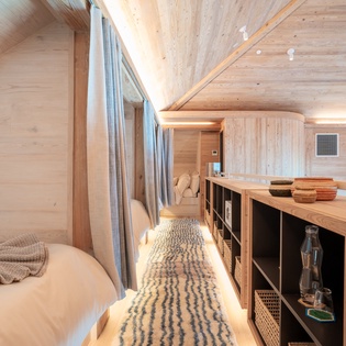 Unwind in your cozy loft bedroom with warm wood beams overhead and plush linens waiting for restful mountain nights.
