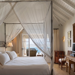 Drift into island dreams beneath billowing canopy netting, where whitewashed beams and warm wooden accents frame your tranquil retreat. Natural light spills in through the terrace doors, blending Caribbean charm with effortless elegance.