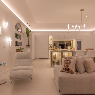 Sink into plush seating in your elegant open-concept living space, where warm lighting and sophisticated design create the perfect atmosphere for relaxation.