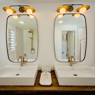 Fresh, modern dual vanity with stylish gold fixtures and natural light—your personal spa-like retreat awaits every morning.